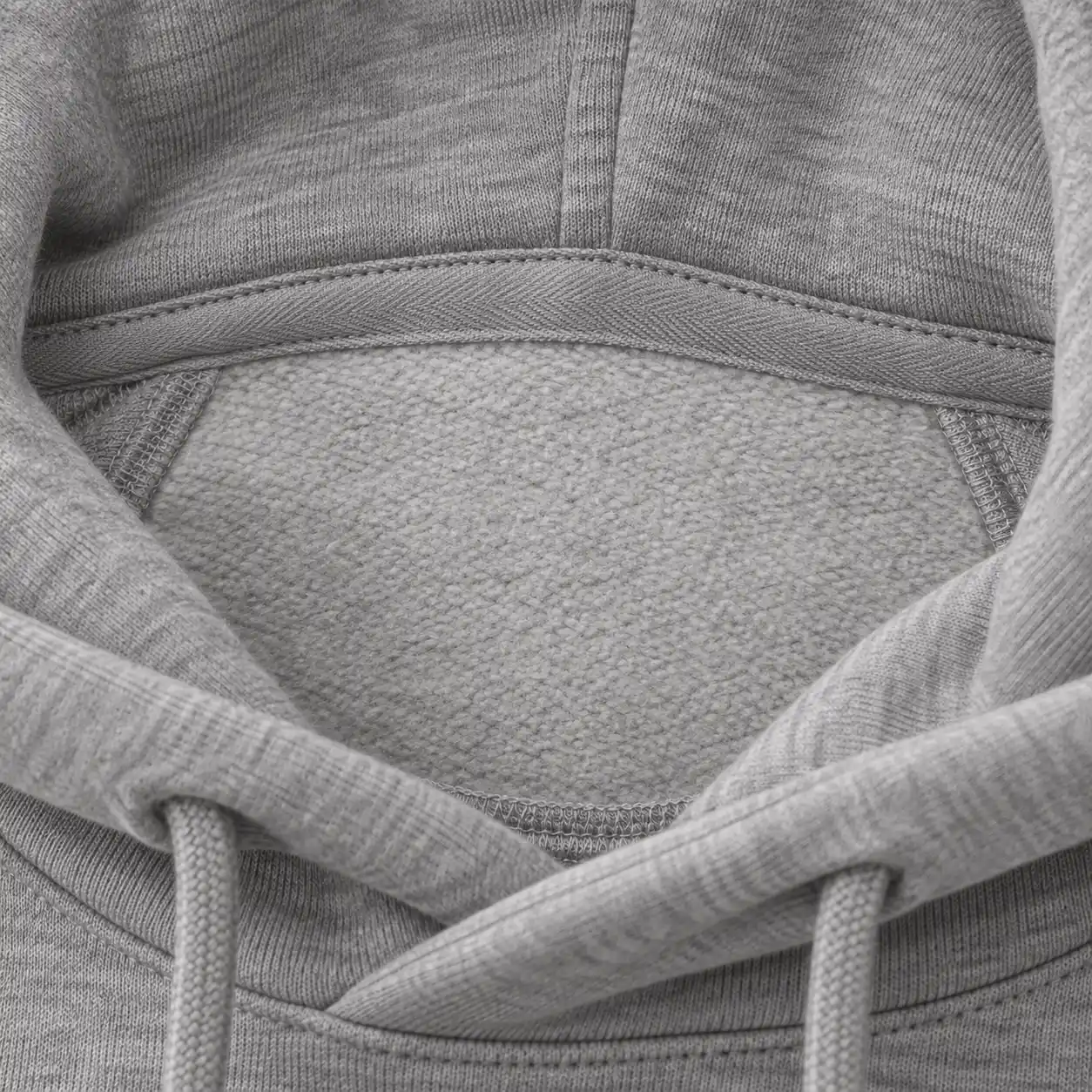 Inside the neck of a grey hoodie: the back-neck tape and the plain area where a label goes.
