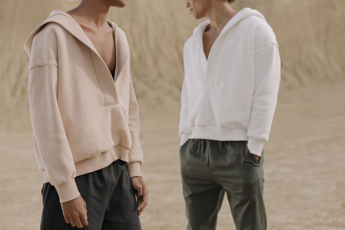 Two people wearing plain heavyweight hoodies.